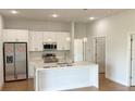 Modern kitchen with stainless steel appliances, a central island with quartz countertop, and elegant pendant lights at 6741 Heavitree Dr, Sebring, FL 33876