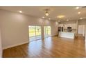 Open floor plan with wood floors, large windows, sliding glass doors, and a modern kitchen with stainless appliances at 6741 Heavitree Dr, Sebring, FL 33876
