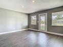 Bright living room with grey walls, white trim, recessed lighting, light wood-look floors, and an exterior door at 8228 Shriver Dr, Orlando, FL 32822