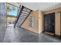 Exterior entrance featuring a black door, staircase, and concrete walkway at 8801 Latrec Ave # 8101, Orlando, FL 32819