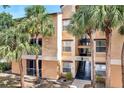 Well-maintained condo building exterior with palm trees and a staircase leading to upper units at 8801 Latrec Ave # 8101, Orlando, FL 32819