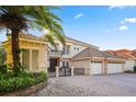An attractive two-story house boasts a tile roof, a gated entrance, and a three-car garage with a brick-paved driveway at 9128 Phillips Grove Ter, Orlando, FL 32836