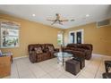 Inviting living room showcasing tile floors, neutral walls, a ceiling fan, and comfortable leather seating at 9128 Phillips Grove Ter, Orlando, FL 32836