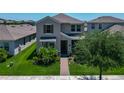 Charming exterior view of a two-story house with a well-manicured lawn and a brick walkway to the front door at 9971 Beach Port Dr, Winter Garden, FL 34787