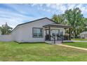 A cozy house with a well-kept lawn, and a charming front porch, complemented by blue skies at 1050 20 St, Orlando, FL 32805