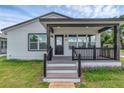 Inviting front porch with dark accents, a brick walkway, and lush green lawn at 1050 20 St, Orlando, FL 32805
