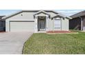 Well-maintained home with a green lawn, mulch landscaping, and a two-car garage at 1111 High Vista Dr, Davenport, FL 33837