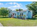 Quaint one-story home with a colorful exterior, mature landscaping, and a charming pink front door at 1225 W Smith St, Orlando, FL 32804
