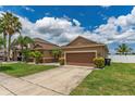 Single-story home featuring a two-car garage, complemented by landscaped bushes and a concrete driveway at 12845 Sawgrass Pine Cir, Orlando, FL 32824