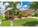 Lovely one-story home with manicured lawn, tropical landscaping, and a two-car garage at 12845 Sawgrass Pine Cir, Orlando, FL 32824