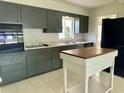 Functional kitchen with gray cabinetry, marble countertops, and an island at 1326 Edmundshire Ln, Orlando, FL 32806