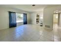 Bright living room featuring neutral tile floors, a built-in bookcase, and a large window at 1326 Edmundshire Ln, Orlando, FL 32806