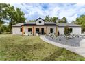 Charming single-story home with modern farmhouse design, inviting front porch, and meticulous landscaping at 13393 Sw 484 Hwy, Ocala, FL 34481