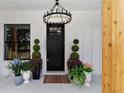 Inviting front door entrance with an elegant chandelier, decorative plants, and modern black accents at 13393 Sw 484 Hwy, Ocala, FL 34481