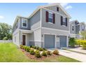 Charming two-story home with gray siding, two-car garage, and meticulously landscaped front yard at 1396 Mirabella Cir, Davenport, FL 33897