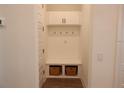 Functional mudroom features built-in storage, including hooks, a bench, and baskets, enhancing organization at 14955 Lebeau Loop, Winter Garden, FL 34787