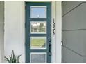 Eye-catching front door with glass panels and a modern design, enhanced by the house number at 15975 Marina Bay Dr, Winter Garden, FL 34787
