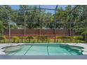 Backyard pool with screened enclosure and brick wall creating a private outdoor space at 1638 Whitney Isles Dr, Windermere, FL 34786