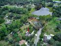 Expansive property featuring a private lake, lush greenery, and a cozy home nestled among the trees at 205 Elaine Pl, Chuluota, FL 32766