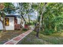 Lush backyard features a brick-lined walkway leading to a tent, set in a private, natural setting at 205 Elaine Pl, Chuluota, FL 32766