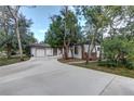 Home with a brick-trimmed garage and freshly poured concrete driveway, framed by mature trees and green landscaping at 205 Elaine Pl, Chuluota, FL 32766