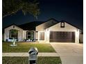 Charming single-Gathering home with a well-manicured lawn and a two-car garage, illuminated at night at 2620 Abbey Ave, Orlando, FL 32833