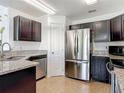 Well-lit kitchen featuring stainless steel appliances, granite countertops, and dark wood cabinets at 2620 Abbey Ave, Orlando, FL 32833