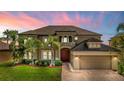 Elegant two-story home featuring lush landscaping, a brick driveway, and a two-car garage at 3041 Boating Blvd, Kissimmee, FL 34746