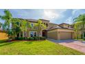 Beautifully landscaped front yard showcasing a luxury home with arched balconies and paver driveway at 3041 Boating Blvd, Kissimmee, FL 34746