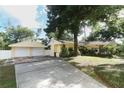 The home includes a detached two-car garage with matching yellow siding and a spacious concrete driveway at 317 White Oak Dr, Altamonte Springs, FL 32701