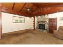 Cozy living room with wood-beam ceiling, stone fireplace, and carpet flooring at 317 White Oak Dr, Altamonte Springs, FL 32701