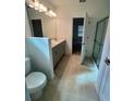 Bright bathroom with double vanity, tile floor, and glass-enclosed shower at 33836 Sky Blossom Cir, Leesburg, FL 34788