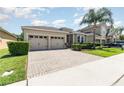 Beautiful home featuring a brick driveway and complemented by lush green landscaping at 4737 Maple Park St, Orlando, FL 32811