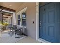 Relaxing front porch with seating and a blue door at 5119 Jones Rd, St Cloud, FL 34771