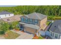 An aerial shot of a two-story home with lush green backyard, screened in porch, and a two-car garage at 5151 Preserve Blvd, St Cloud, FL 34772