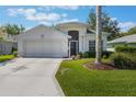 Charming single-story home with a two-car garage, lovely landscaping, and a well-manicured lawn at 5560 Squires Dr, Leesburg, FL 34748