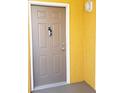 Beige front door with a key lockbox, and yellow wall at 6169 Metrowest Blvd # 308, Orlando, FL 32835