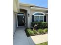 Inviting front entrance featuring a dark door, manicured landscaping, and a decorative lion statue at 6800 Se 12Th Pl, Ocala, FL 34472