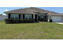 Attractive one-story home boasting a well-maintained lawn, complemented by dark shutters and a clean garage door at 6800 Se 12Th Pl, Ocala, FL 34472