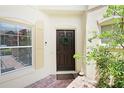 Inviting front entrance with a wreath, lovely plants, and a window with white blinds at 6941 Piazza St, Orlando, FL 32819