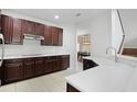 Open kitchen showcasing stainless steel appliances, a breakfast bar, and dark wood cabinetry at 6941 Piazza St, Orlando, FL 32819