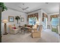 Bright living room with comfortable seating, large windows, and a ceiling fan at 6955 Della Dr # 41, Orlando, FL 32819