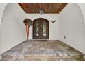 Elegant front entrance featuring a stone-tiled entryway and ornate double doors at 6969 Edgeworth Dr, Orlando, FL 32819