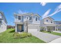 Inviting two-story home with a light blue exterior, white accents and well-kept lawn at 7263 Oakmoss Loop, Davenport, FL 33837