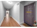 Hallway with a wooden floor and a view of the purple apartment door at 860 N Orange Ave # 448, Orlando, FL 32801