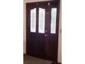 Elegant front door with decorative glass panels and side lights, adding a touch of sophistication to the entrance at 983 Bucksaw Pl, Longwood, FL 32750