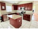 Well-lit kitchen with dark cabinets, granite countertops, stainless steel appliances, and center island at 12756 Maribou Cir, Orlando, FL 32828