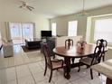 Open-concept living room and dining area with tile floors, plenty of light, and sliding doors to patio at 12756 Maribou Cir, Orlando, FL 32828