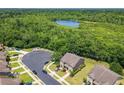 Aerial view of a home with surrounding lush greenery and a serene lake at 1551 Peterson Pl, Sanford, FL 32773
