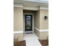 Close-up of the front door with a welcome mat at 1575 Aspen Ave, Davenport, FL 33837